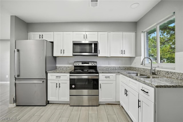 125/127 Gordon Ave S, Lehigh Acres, FL 33973 - kitchen featuring stainless steel appliances, white cabinetry, and light stone counters