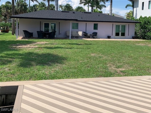 432 Oak Ave, Naples, FL 34108 - back of property with french doors, stucco siding, a lawn, and a patio