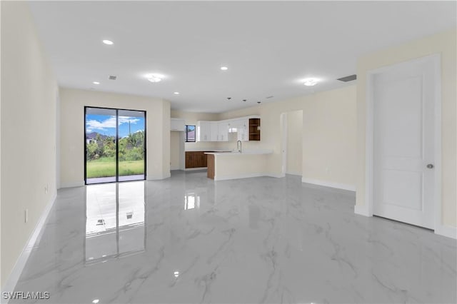 3307 18th St SW, Lehigh Acres, FL 33976 - unfurnished living room with light marble finish flooring and recessed lighting