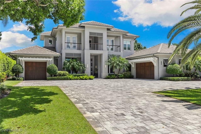 745 Riviera Dr, Naples, FL 34103 - view of front facade featuring a balcony, a garage, decorative driveway, a front yard, and a tiled roof
