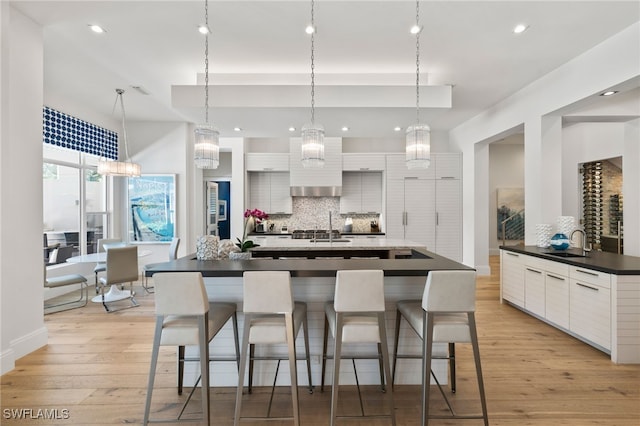 745 Riviera Dr, Naples, FL 34103 - kitchen with backsplash, modern cabinets, light wood-type flooring, a kitchen breakfast bar, and recessed lighting