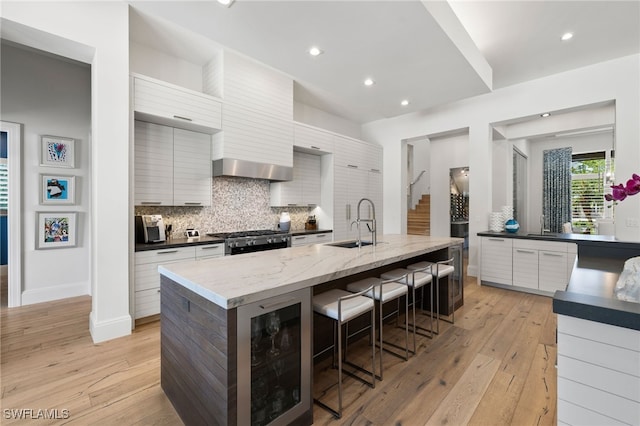 745 Riviera Dr, Naples, FL 34103 - kitchen with modern cabinets, tasteful backsplash, stove, a breakfast bar area, and recessed lighting