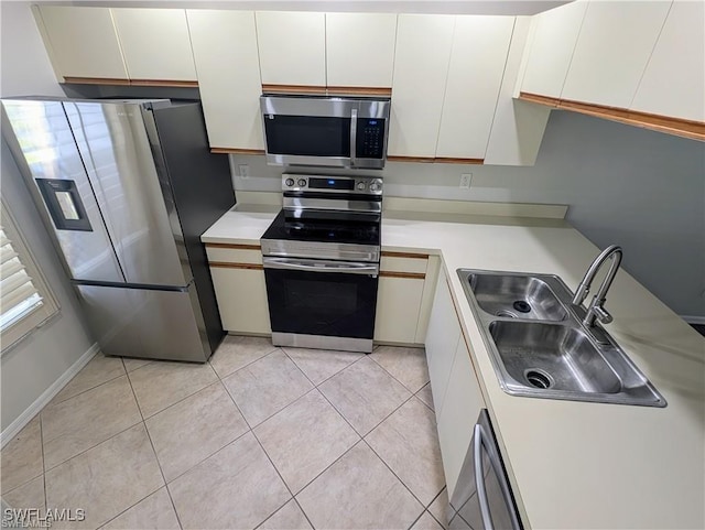 1915 Courtyard Way Unit G102, Naples, FL 34112 - kitchen with stainless steel appliances, light countertops, white cabinets, and light tile patterned floors