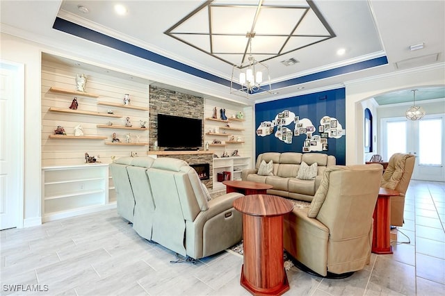 2110 Antigua Ln, Naples, FL 34120 - living room with a chandelier, crown molding, arched walkways, a fireplace, and a raised ceiling