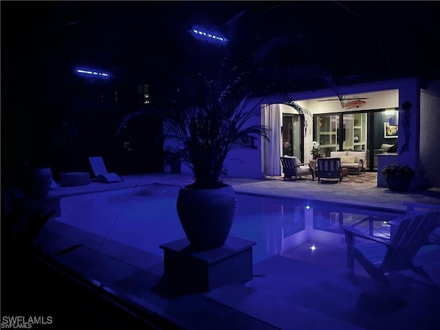 2110 Antigua Ln, Naples, FL 34120 - pool at night with outdoor lounge area, an outdoor pool, a patio, and ceiling fan