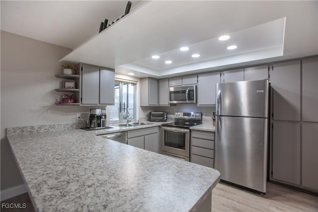 195 E Mariana Ave, North Fort Myers, FL 33917 - kitchen with a tray ceiling, stainless steel appliances, open shelves, a peninsula, and recessed lighting