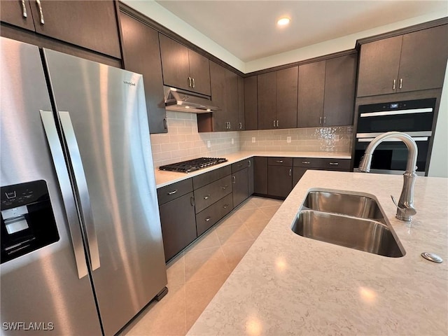 16381 Preservation Blvd, Punta Gorda, FL 33982 - kitchen with stainless steel appliances, under cabinet range hood, decorative backsplash, dark brown cabinetry, and recessed lighting