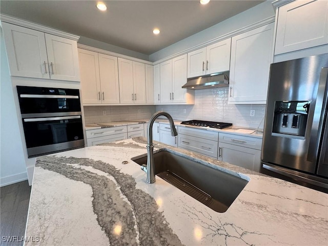 16106 Preservation Blvd, Punta Gorda, FL 33982 - kitchen featuring stainless steel appliances, under cabinet range hood, light stone countertops, backsplash, and recessed lighting