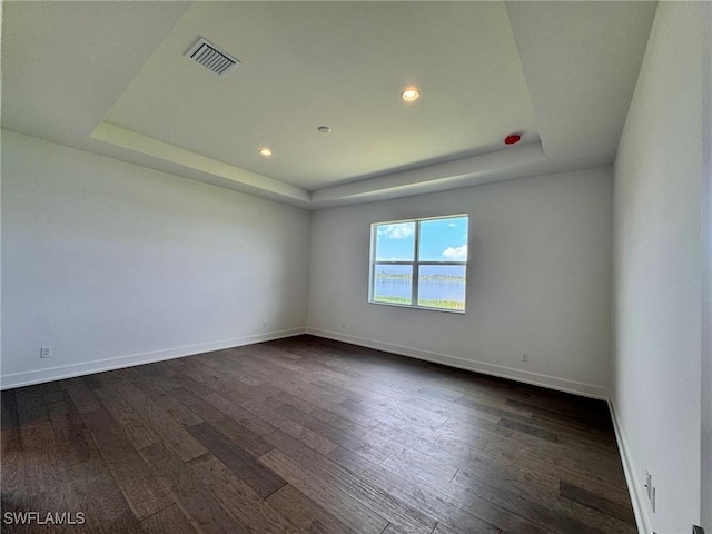 16106 Preservation Blvd, Punta Gorda, FL 33982 - empty room with a tray ceiling, dark wood-style floors, and recessed lighting