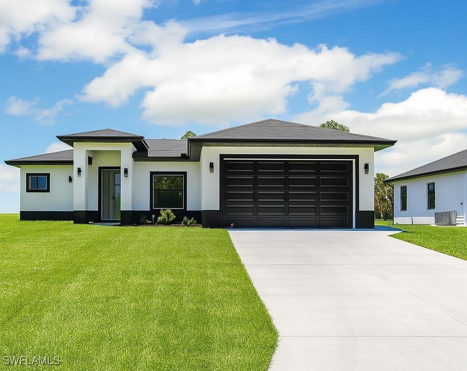 3301 8th St SW, Lehigh Acres, FL 33976 - prairie-style home with stucco siding, driveway, a garage, and a front lawn