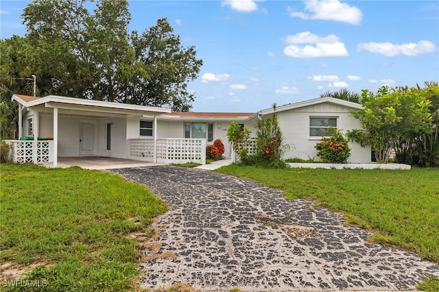 138 Dowling Ave NE, Port Charlotte, FL 33952 - ranch-style house featuring asphalt driveway, a carport, and a front yard