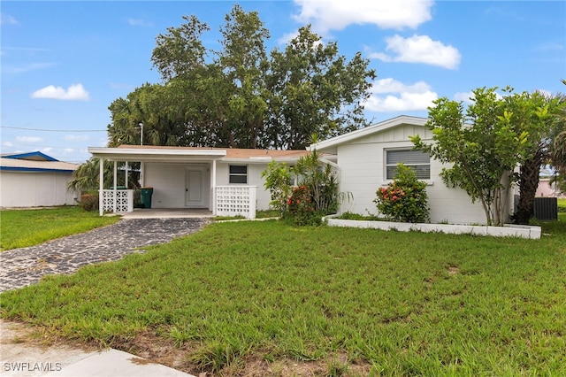 138 Dowling Ave NE, Port Charlotte, FL 33952 - single story home with a carport, driveway, a front lawn, and board and batten siding