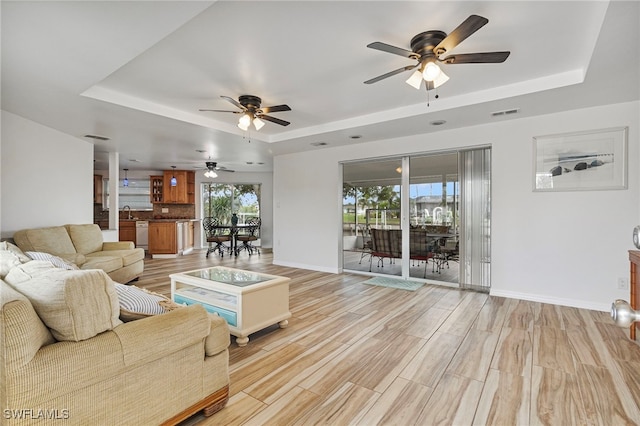 138 Dowling Ave NE, Port Charlotte, FL 33952 - living area featuring a raised ceiling, ceiling fan, and light wood-style flooring
