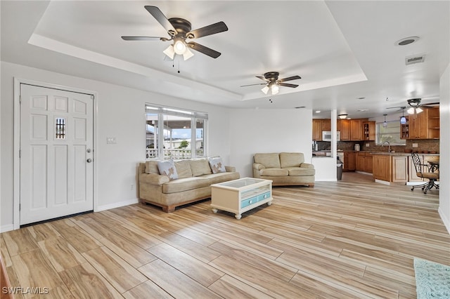 138 Dowling Ave NE, Port Charlotte, FL 33952 - living area featuring a raised ceiling, a ceiling fan, and light wood finished floors