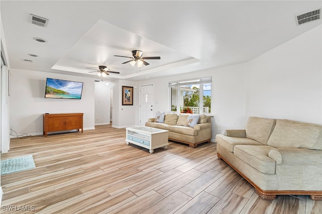 138 Dowling Ave NE, Port Charlotte, FL 33952 - living room featuring a tray ceiling, light wood-style floors, and a ceiling fan