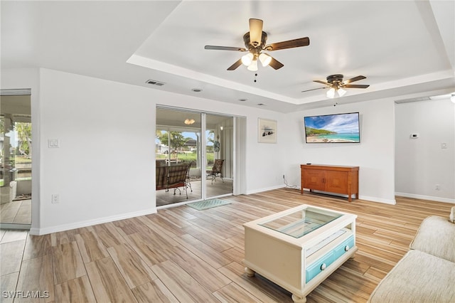 138 Dowling Ave NE, Port Charlotte, FL 33952 - living area featuring a tray ceiling, a ceiling fan, and light wood-style flooring