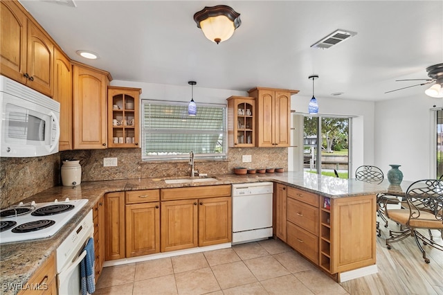 138 Dowling Ave NE, Port Charlotte, FL 33952 - kitchen featuring white appliances, a peninsula, stone countertops, backsplash, and decorative light fixtures