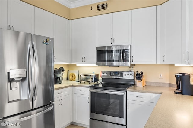 3904 Forest Glen Blvd Unit 102, Naples, FL 34114 - kitchen featuring appliances with stainless steel finishes, light countertops, white cabinets, and crown molding