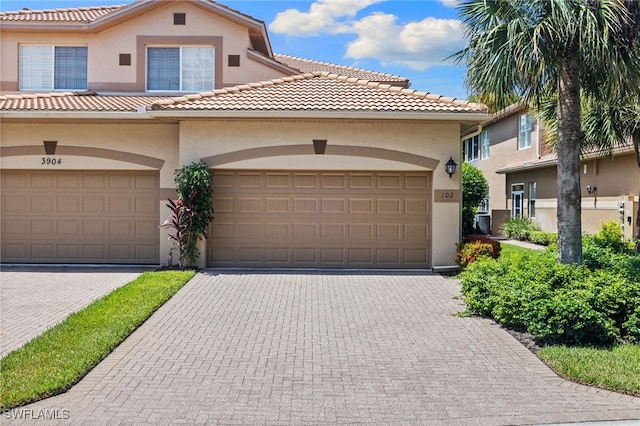 3904 Forest Glen Blvd Unit 102, Naples, FL 34114 - mediterranean / spanish-style house featuring stucco siding, a tile roof, and driveway