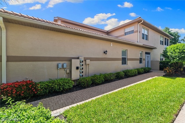 3904 Forest Glen Blvd Unit 102, Naples, FL 34114 - view of home's exterior featuring stucco siding and a lawn