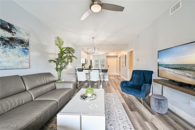9175 Celeste Dr Unit 305, Naples, FL 34113 - living area with light wood-style flooring, a ceiling fan, and a chandelier