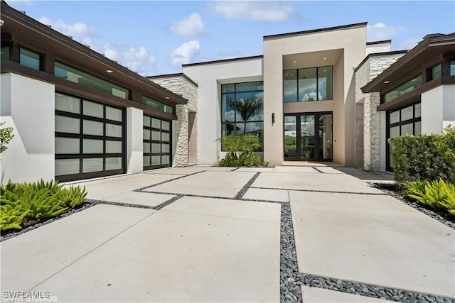 10411 Via Parma Way, Miromar Lakes, FL 33913 - doorway to property featuring stone siding, stucco siding, and concrete driveway