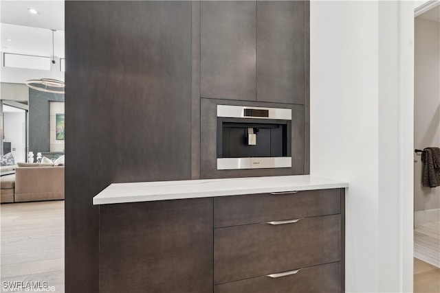 10411 Via Parma Way, Miromar Lakes, FL 33913 - kitchen view of modern cabinets, dark brown cabinetry, and light countertops