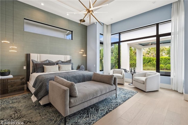 10411 Via Parma Way, Miromar Lakes, FL 33913 - bedroom with a high ceiling, a chandelier, and wood finished floors