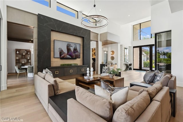 10411 Via Parma Way, Miromar Lakes, FL 33913 - living room with a towering ceiling, a chandelier, and light wood-type flooring