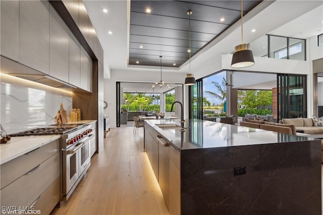 10411 Via Parma Way, Miromar Lakes, FL 33913 - kitchen featuring modern cabinets, double oven range, light wood-style flooring, open floor plan, and plenty of natural light