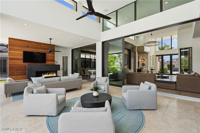 10411 Via Parma Way, Miromar Lakes, FL 33913 - living area featuring ceiling fan, a towering ceiling, plenty of natural light, a warm lit fireplace, and recessed lighting