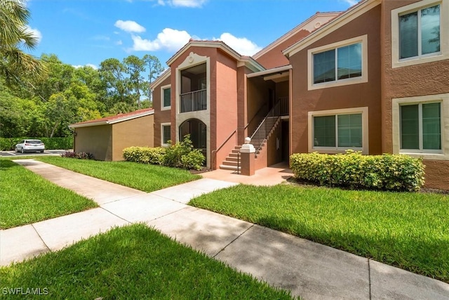1170 Reserve Way Unit 107, Naples, FL 34105 - view of front of property featuring stucco siding, a front yard, and stairway