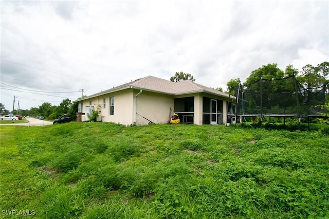 4856/4858 24th St SW, Lehigh Acres, FL 33993 - view of home's exterior featuring stucco siding, a trampoline, and a sunroom