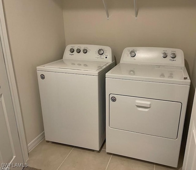 15141 Wildflower Cir, Naples, FL 34119 - laundry area with washing machine and dryer and light tile patterned flooring