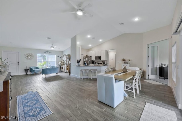 2922 20th St SW, Lehigh Acres, FL 34120 - kitchen featuring a ceiling fan, stainless steel microwave, light wood-style flooring, white cabinets, and vaulted ceiling