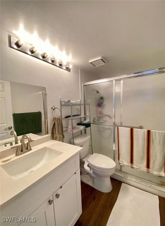 5735 Foxlake Dr Unit 1, North Fort Myers, FL 33917 - full bath with vanity, wood finished floors, and a shower with shower door