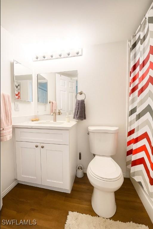 5735 Foxlake Dr Unit 1, North Fort Myers, FL 33917 - bathroom featuring wood finished floors, vanity, and curtained shower