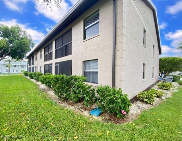 5735 Foxlake Dr Unit 1, North Fort Myers, FL 33917 - view of property exterior with stucco siding and a yard
