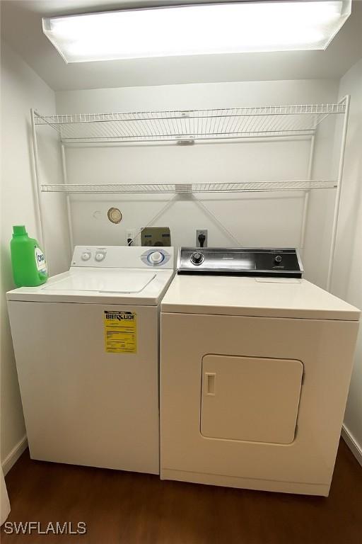 5735 Foxlake Dr Unit 1, North Fort Myers, FL 33917 - washroom with washing machine and clothes dryer and dark wood-style flooring