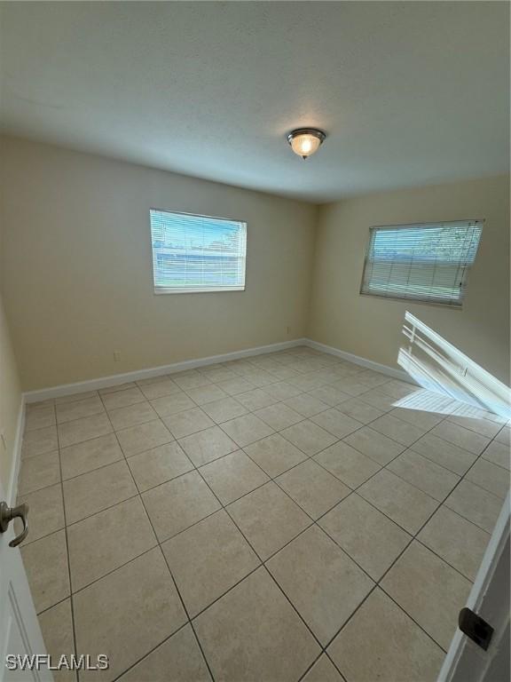 401 W Oregon Rd, Lehigh Acres, FL 33971 - unfurnished room with light tile patterned flooring and plenty of natural light