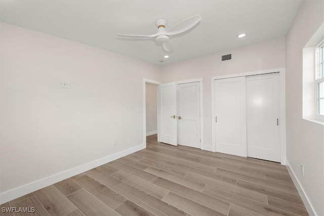 8336 Lagoon Rd, Fort Myers Beach, FL 33931 - unfurnished bedroom featuring multiple closets, light wood finished floors, ceiling fan, and recessed lighting