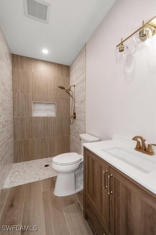 8336 Lagoon Rd, Fort Myers Beach, FL 33931 - bathroom featuring tiled shower, vanity, and wood finished floors