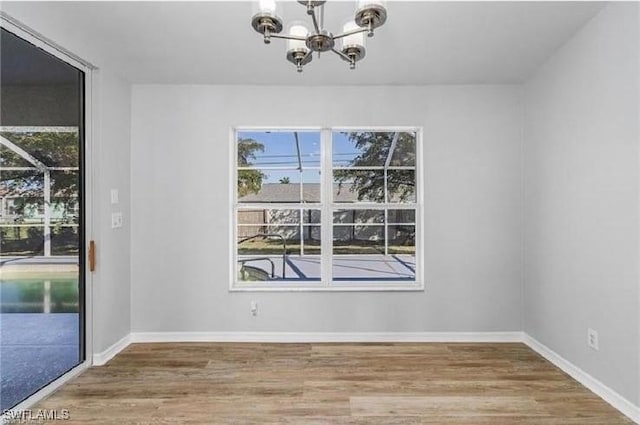 609 SW 22nd St, Cape Coral, FL 33991 - unfurnished dining area featuring a chandelier, plenty of natural light, and wood finished floors