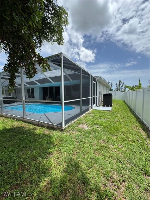609 SW 22nd St, Cape Coral, FL 33991 - rear view of property featuring a fenced backyard, an outdoor pool, and glass enclosure