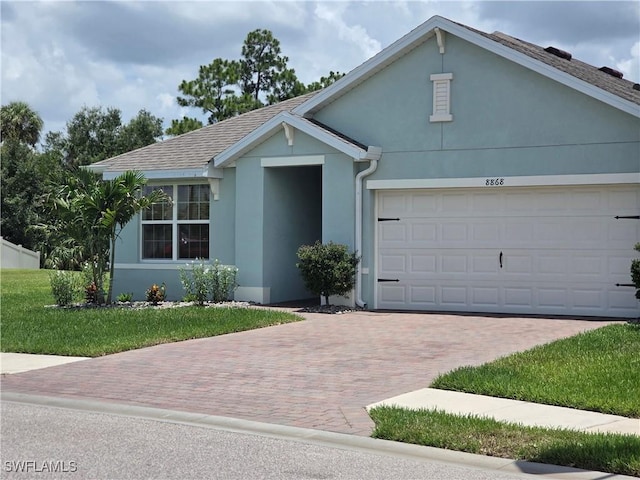 8868 E Cascade Price Cir, North Fort Myers, FL 33917 - ranch-style home featuring stucco siding, decorative driveway, an attached garage, and a front yard