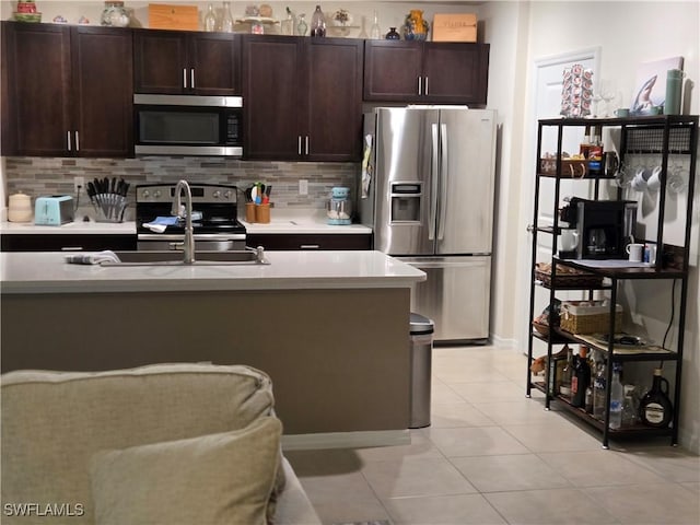 8868 E Cascade Price Cir, North Fort Myers, FL 33917 - kitchen with stainless steel appliances, light tile patterned flooring, dark brown cabinets, and backsplash