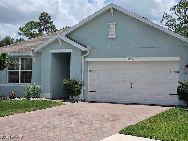 8868 E Cascade Price Cir, North Fort Myers, FL 33917 - view of front of property with decorative driveway, stucco siding, and a garage