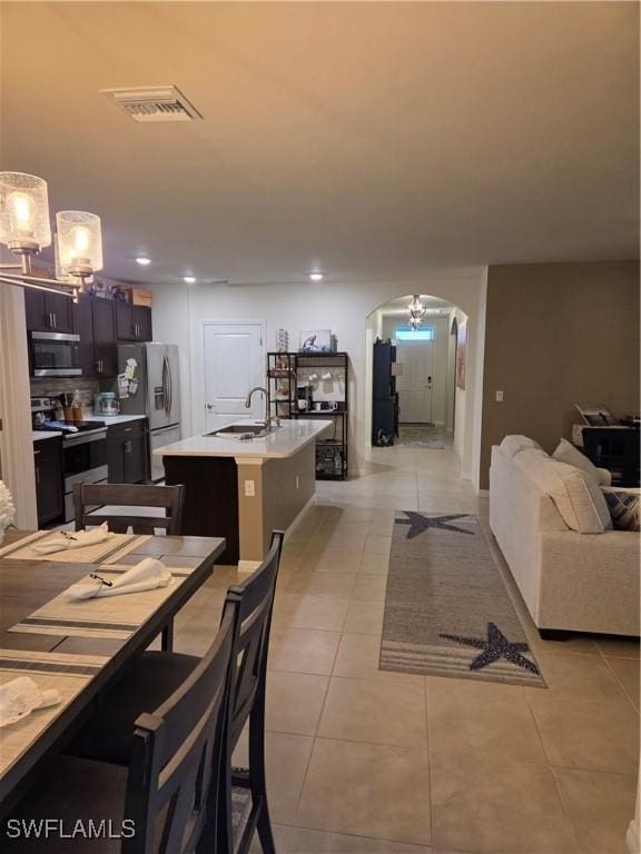 8868 E Cascade Price Cir, North Fort Myers, FL 33917 - dining space with arched walkways, light tile patterned floors, a chandelier, and recessed lighting