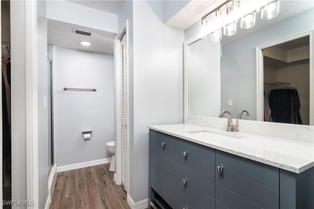 9580 Victoria Ln Unit A106, Naples, FL 34109 - bathroom with a walk in closet, vanity, wood finished floors, and a stall shower