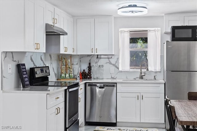 3064 Connecticut Ave, Naples, FL 34112 - kitchen with stainless steel appliances, under cabinet range hood, white cabinetry, light countertops, and tasteful backsplash